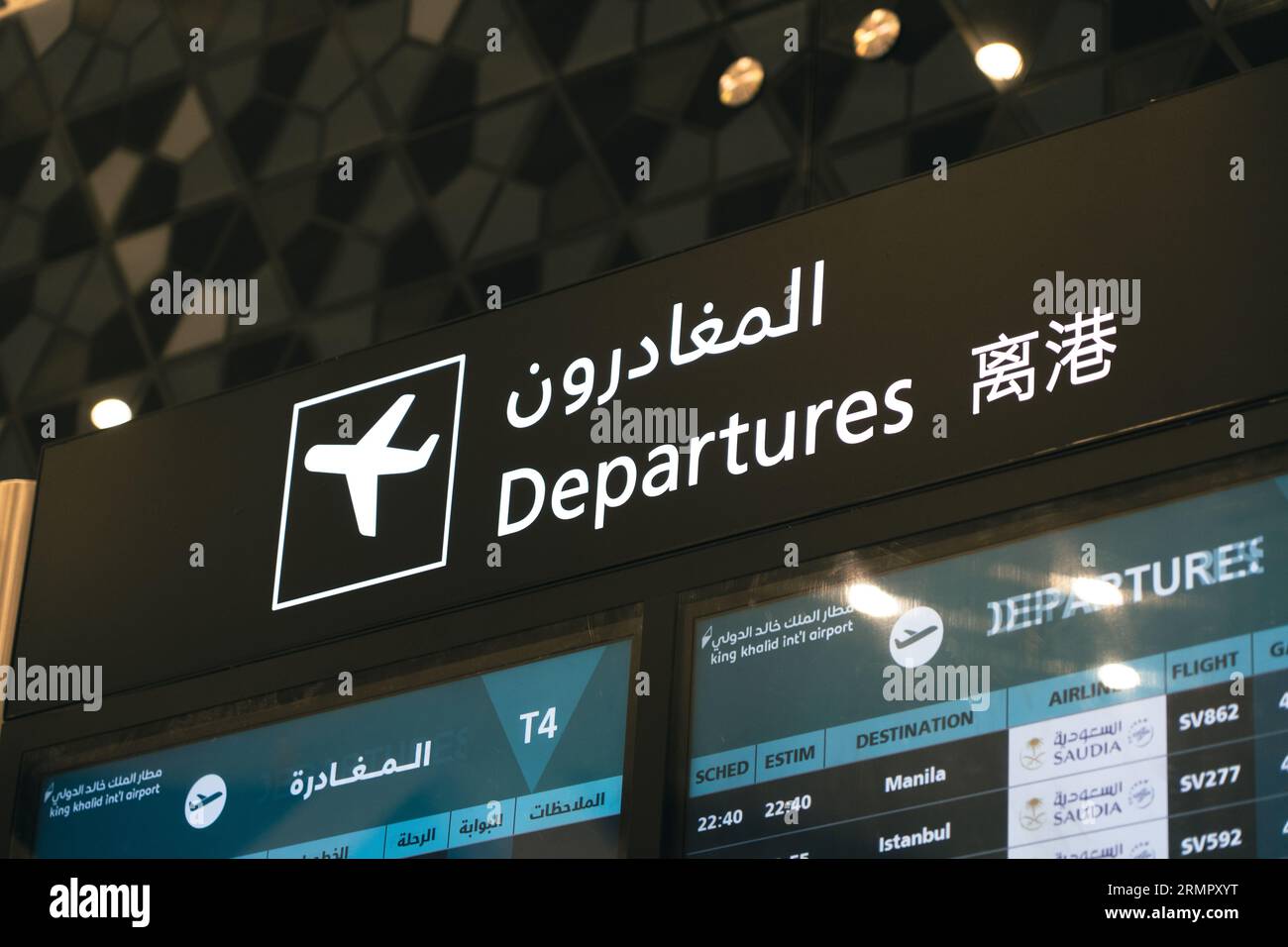 Panneau de départ à un aéroport avec chinois et arabe Banque D'Images