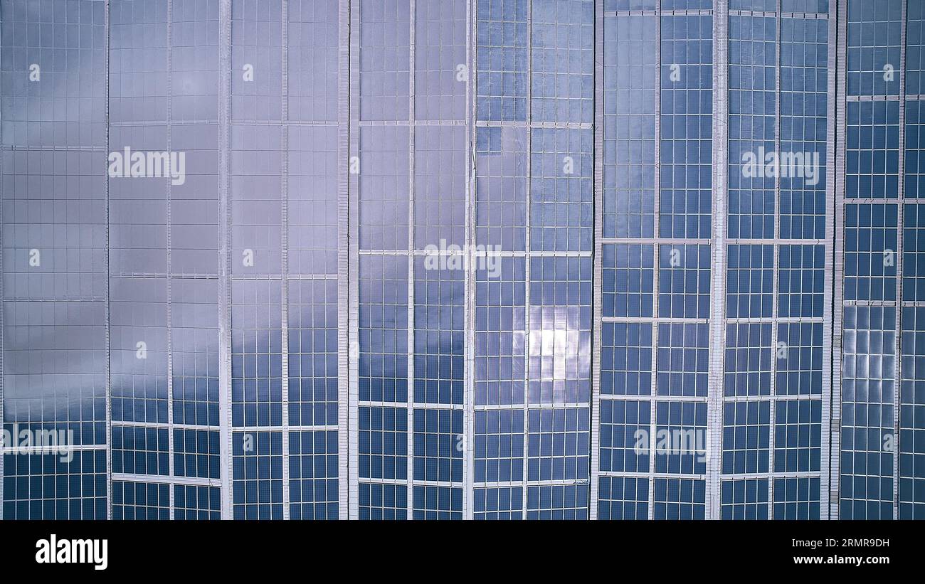 Vue aérienne de haut en bas du bâtiment industriel avec panneaux photovoltaïques installés sur le toit. Panneau solaire sur toit de bâtiment industriel. Panneaux photovoltaïques solaires aeria Banque D'Images