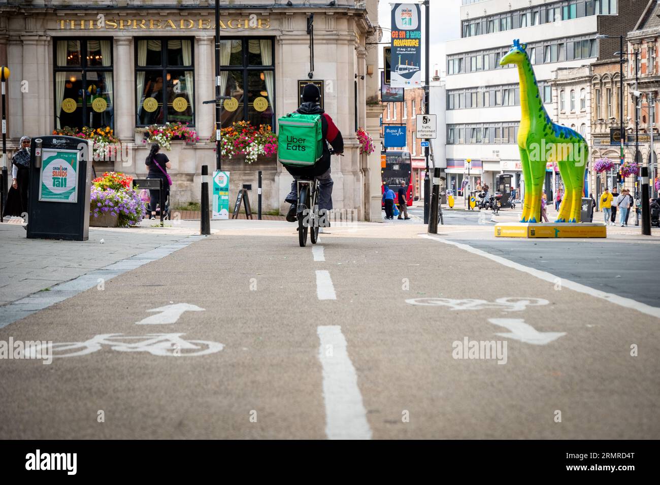 CROYDON, LONDRES- 29 AOÛT 2023 : voie cyclable dans le centre-ville de Croydon utilisée par un livreur de vélos Uber Eats Banque D'Images