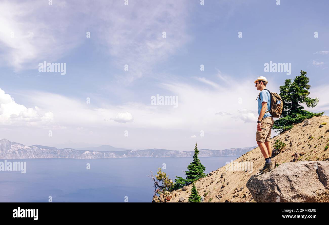 Homme debout après une randonnée au sommet avec vue sur un lac volcanique pittoresque Banque D'Images