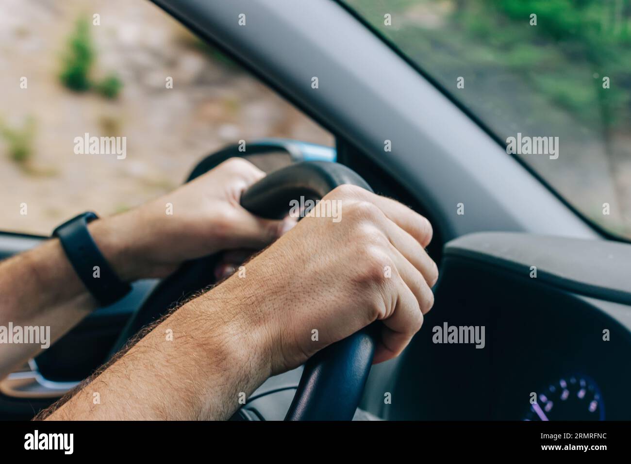Gros plan des mains masculines sur le volant, Road trip, vue de l'intérieur de la voiture Banque D'Images