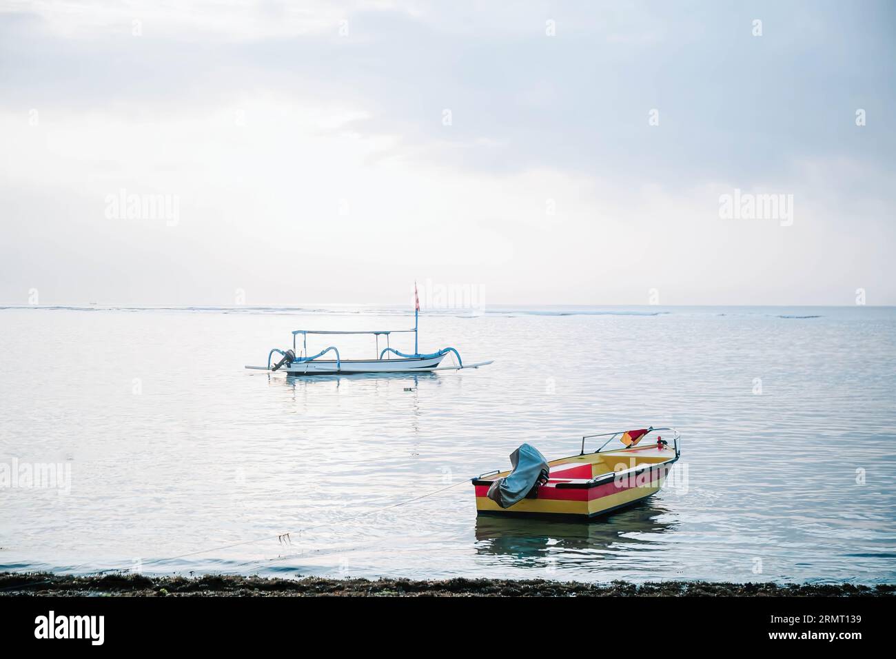 Portrait ou plan vertical d'un bateau coloré avec un bateau traditionnel flottant sur la plage le matin Banque D'Images
