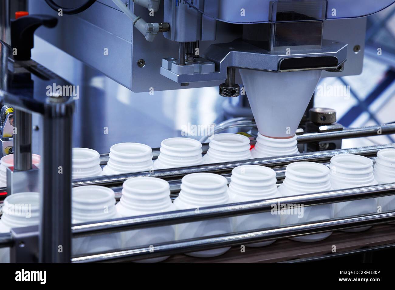 Pilule médecine capsules sont de remplir le flacon en plastique blanc sur la ligne de production machine convoyeur à l'usine. Banque D'Images