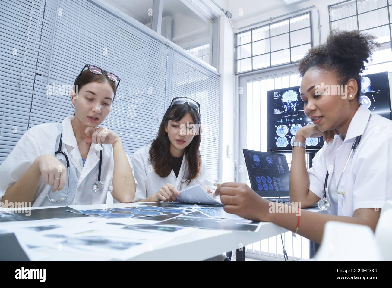 jeune femme médecin étudiant stage équipe réunion de groupe et de discuter de cas de patient de traitement de chirurgie de cancer du cerveau au bureau de laboratoire à l'hospice Banque D'Images