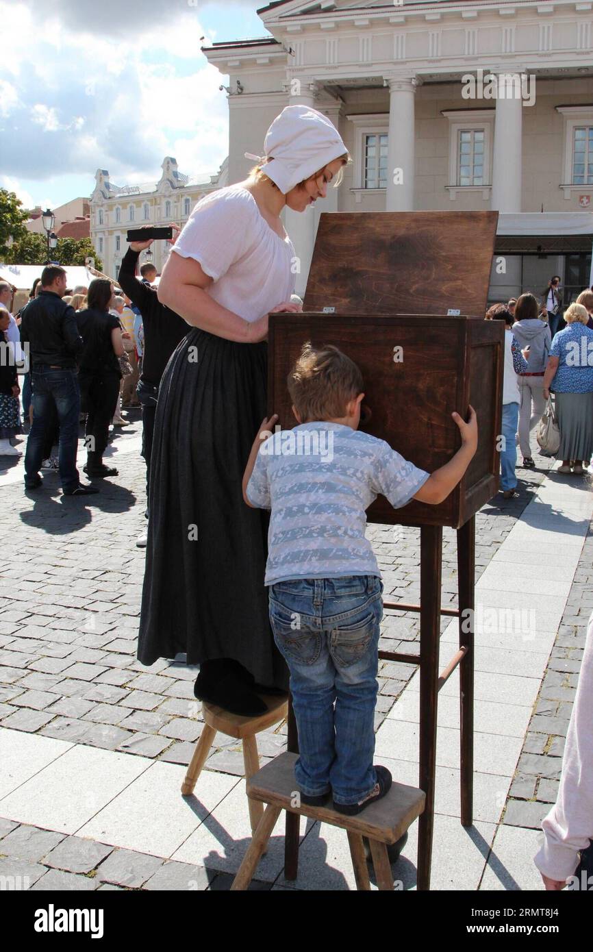 (140822) -- VILNIUS, 22 août 2014 -- Un enfant regarde des images en mouvement à la foire Bartholomew à Vilnius, Lituanie, le 22 août 2014. La foire de deux jours a débuté ici vendredi, apportant de la ferronnerie, des articles en bois, des tissus, des œuvres en céramique faites par des artisans locaux aux visiteurs. La Foire de Bartholomew a lieu régulièrement en Lituanie depuis 2009, en commémoration de Saint Bartholomew s Day, ainsi que l'exposition de l'artisanat traditionnel lituanien. ) LITUANIE-VILNIUS-LEISURE-BATHOLOMEW FOIRE MildaxJukneviciute PUBLICATIONxNOTxINxCHN Vilnius août 22 2014 a enfants regarde photos en mouvement SUR le bar Banque D'Images