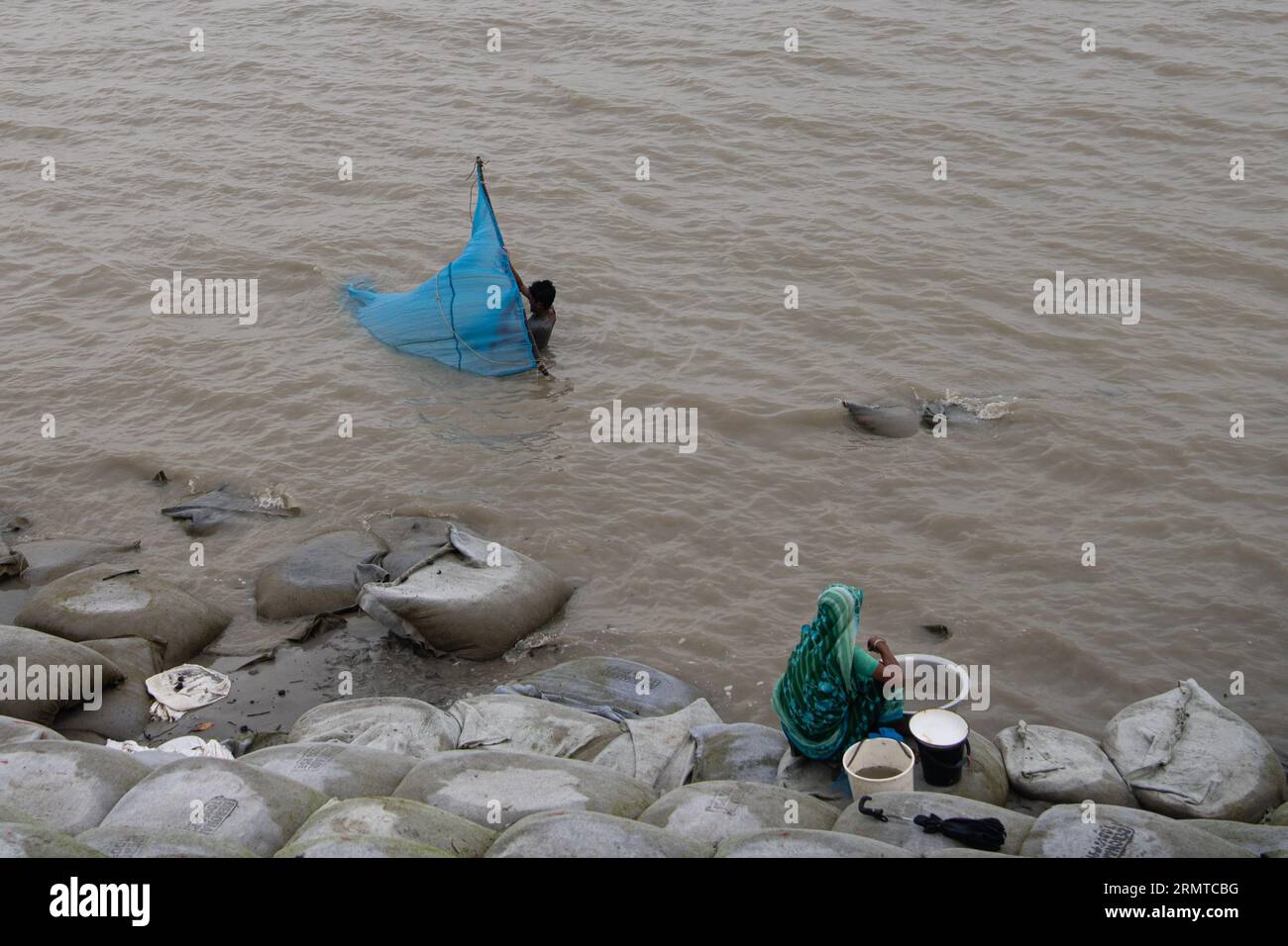 26 août 2023, Khulna, Bangladesh : un homme est vu pêcher et attraper des crabes sur la rivière Shibsha. Il n'y a pas si longtemps, Kalabogi, un village côtier du Bangladesh, était plein de terres cultivables jusqu'à ce que la montée du niveau de la mer commence à envahir la région jusqu'au golfe du Bengale. De fréquents cyclones et inondations frappent le village depuis la fin des années 1990 En 2009, un cyclone majeur nommé Aila a détruit les 1 400 kilomètres de remblais du pays, 8 800 kilomètres de routes et environ 3 50 000 acres de terres agricoles. Plusieurs centaines de personnes auraient été tuées dans la catastrophe. Les fermiers de Kalabogi wer Banque D'Images