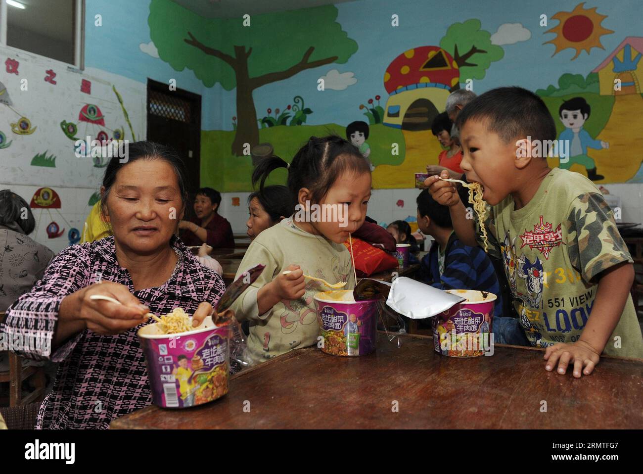 (140902) -CHONGQING, le 2 septembre 2014 -- Li Zhong (à droite) et sa sœur Li Tingting (à droite) prennent leur petit déjeuner dans un refuge après avoir été évacués du township pluvial du comté de Yunyang, dans la municipalité de Chongqing du sud-ouest de la Chine, le 2 septembre 2014. Huit personnes sont mortes et 24 autres étaient portées disparues au début de mardi après que des pluies torrentielles ont apporté des glissements de terrain à Chongqing, a déclaré le siège des secours locaux. Plus de 500 sauveteurs professionnels ont évacué plus de 7 000 résidents dans neuf townships inondés de pluie dans le comté de Yunyang vers des endroits sûrs, a déclaré le siège. (wf) CHINA-CHONGQING-RAINSTORM (CN) ChenxCheng Banque D'Images