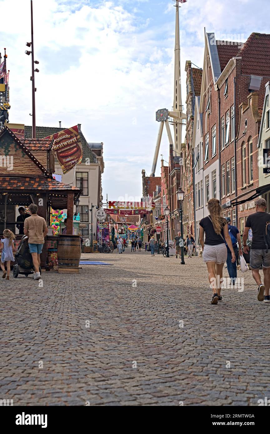 Vieille rue hollandaise pittoresque avec pignon d'horloge, bâtiments à pignons étagés dans le vieux centre-ville. Une foire dans la rue commerçante avec des gens qui marchent Banque D'Images