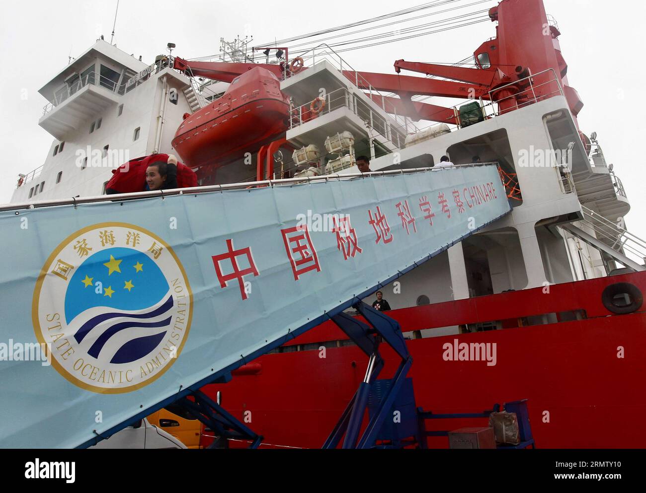 (140923) -- SHANGHAI, le 23 septembre 2014 -- des membres du personnel transportent des sacs du brise-glace Xuelong, ou Dragon des neiges, au port de Shanghai, dans l'est de la Chine, le 23 septembre 2014. Xuelong est parti de Shanghai le 11 juillet et a depuis parcouru quelque 22 000 km pour explorer des zones clés telles que la mer de Béring, la mer de Tchoukchi et le bassin du Canada. Il a voyagé aussi loin que 81,11 degrés de latitude nord et 156,30 degrés de longitude est, a dit l'équipe.) (lfj) CHINA-SHANGHAI-ICEBREAKER XUELONG-RETURN (CN) DingxTing PUBLICATIONxNOTxINxCHN Shanghai sept 23 2014 les membres du personnel transportent des sacs de Icebreaker XUELONG ou Snow Dr Banque D'Images