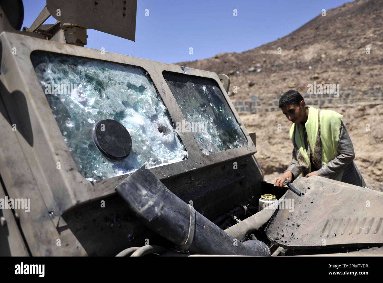 (140923) -- SANAA, 23 septembre 2014 -- Un Yéménite regarde un véhicule blindé détruit lors d'affrontements entre les rebelles chiites houthis et l'armée à Sanaa, au Yémen, le 23 septembre 2014. Le groupe houthi et le gouvernement yéménite ont signé un accord de cessez-le-feu dimanche, mettant fin à des affrontements d'une semaine qui ont fait plus de 400 morts. Les combattants houthis ont resserré leur contrôle sur la plupart des quartiers de la capitale jusqu'à mardi, déployant des combattants pour garder les installations gouvernementales et mettant en place des points de contrôle dans la ville. YEMEN-SANAA-CLASH-AFTERMATH HanixAli PUBLICATIONxNOTxINxCHN Sanaa sept 23 2014 a Yemeni Ma Banque D'Images