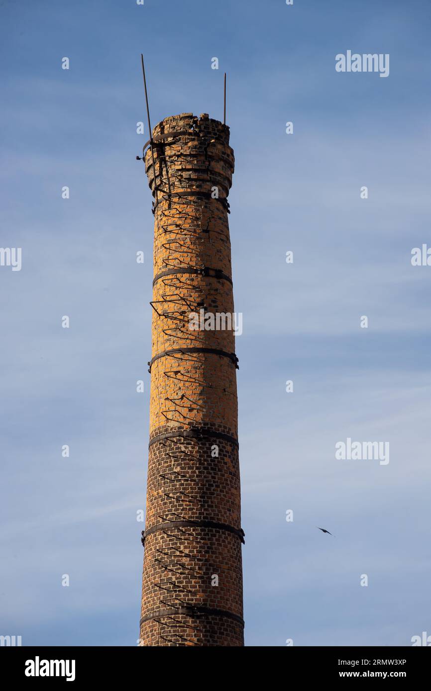 vieille usine ou cheminée de brique d'entreprise atteignant pour le ciel. Banque D'Images