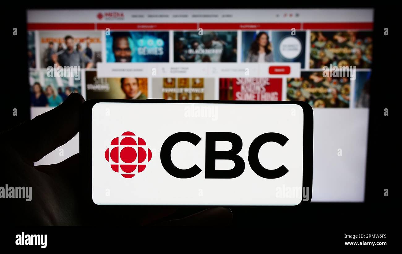 Personne tenant un téléphone intelligent avec le logo de la Société radio-Canada (SRC) à l'écran devant le site Web. Concentrez-vous sur l'affichage du téléphone. Banque D'Images Personne tenant un téléphone intelligent avec le logo de la Société radio-Canada (SRC) à l'écran devant le site Web. Concentrez-vous sur l'affichage du téléphone. Banque D'Images