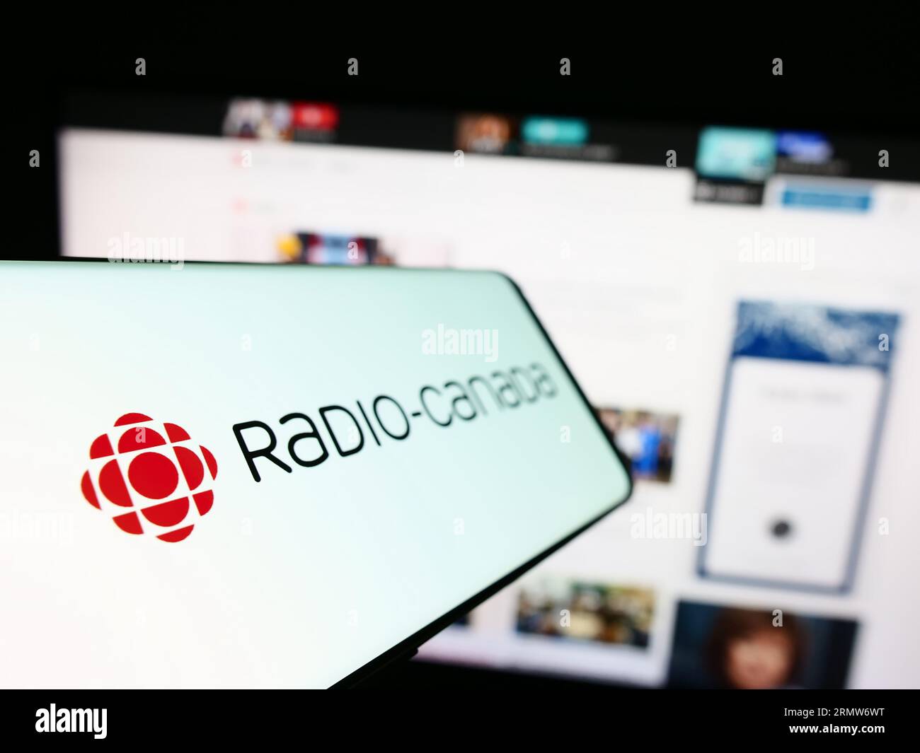 Téléphone intelligent avec logo du radiodiffuseur public radio-Canada (CBC) à l'écran devant le site Web de l'entreprise. Effectuez le focus sur la gauche de l'écran du téléphone. Banque D'Images