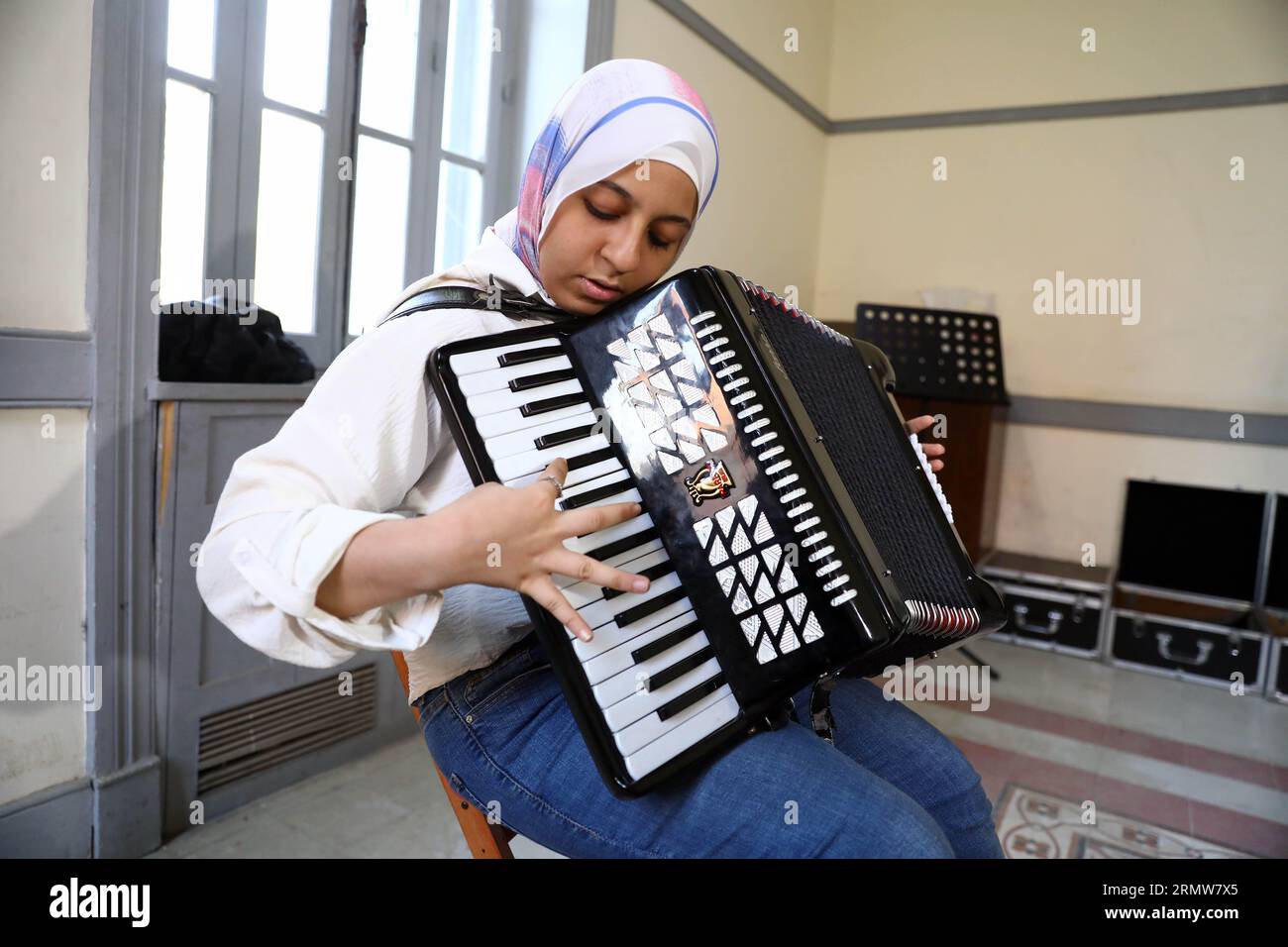 Le Caire, Égypte. 27 août 2023. Une fille pratique l’accordéon pendant un cours de musique à la Maison de l’Art et de la Culture au Caire, en Égypte, le 27 août 2023. POUR ALLER AVEC 'Feature : une école de musique à but non lucratif au Caire offre des opportunités de changement de vie pour les jeunes défavoriséss' crédit : Ahmed Gomaa/Xinhua/Alamy Live News Banque D'Images