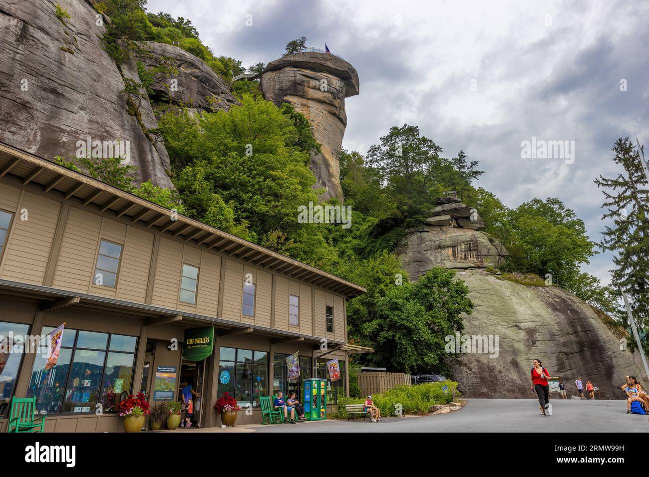 Chimney Rock, Caroline du Nord, États-Unis - 11 août 2023 : Chimney Rock domine les gens et boutique de cadeaux au-dessous du parc d'État de Chimney Rock. Banque D'Images