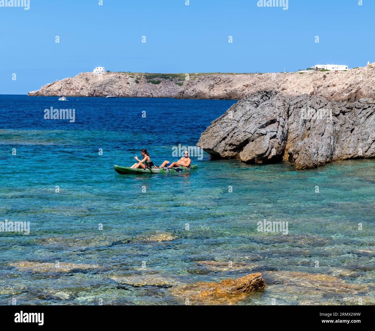 Un jeune couple dans un kayak Arenal d'en castell Menorca Espagne. Banque D'Images
