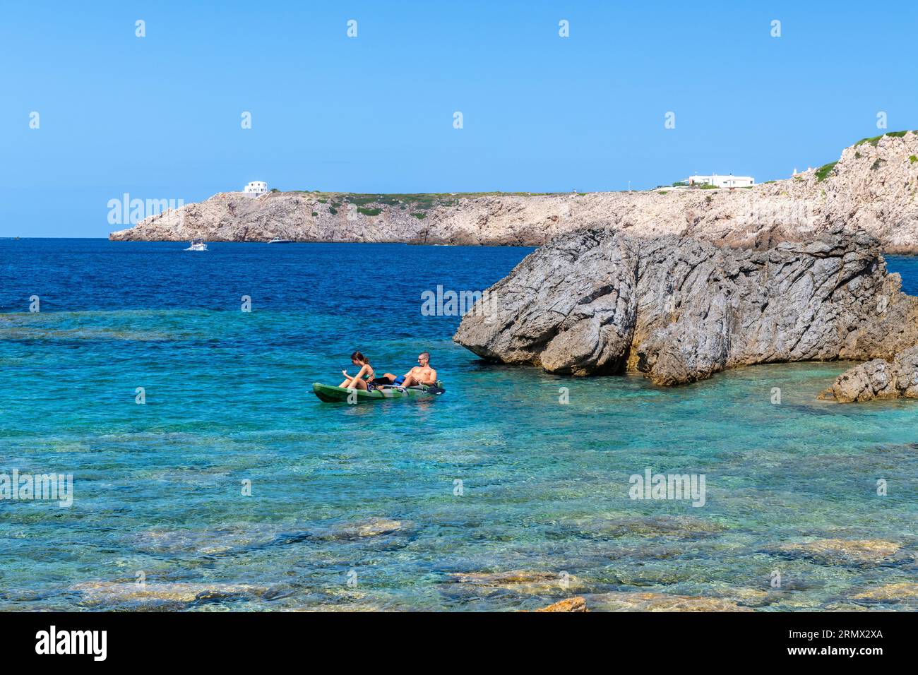 Un jeune couple dans un kayak Arenal d'en castell Menorca Espagne. Banque D'Images