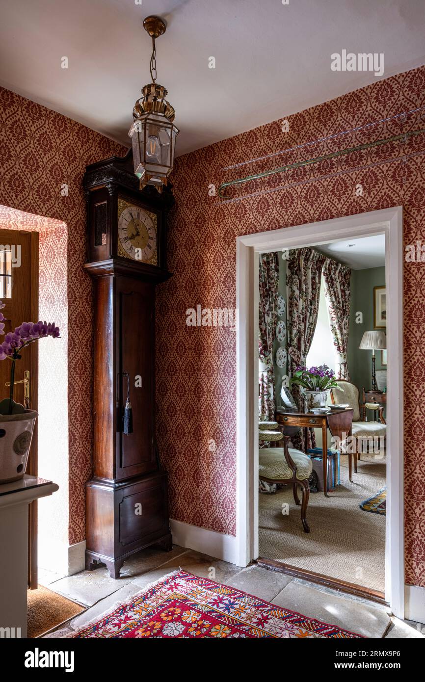 Tissu ancien grand-père et papier peint en 'Furnvilll' avec tapis d'Alep dans le hall d'entrée géorgien du 18e siècle, Northamptonshire, Royaume-Uni Banque D'Images