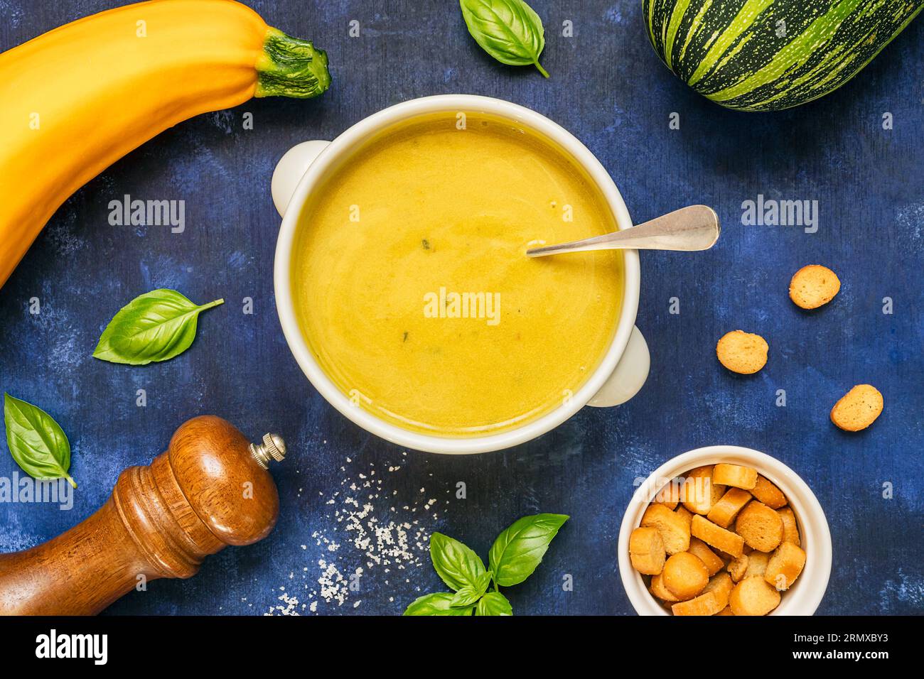 Soupe végétarienne de courgettes maison dans un bol blanc sur fond bleu, vue de dessus Banque D'Images