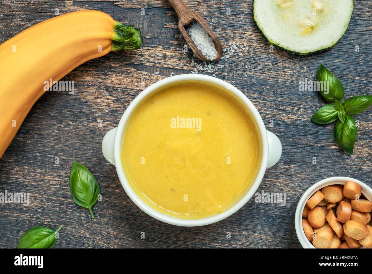 Soupe végétarienne de courgettes dans un bol blanc sur un fond en bois, vue de dessus Banque D'Images