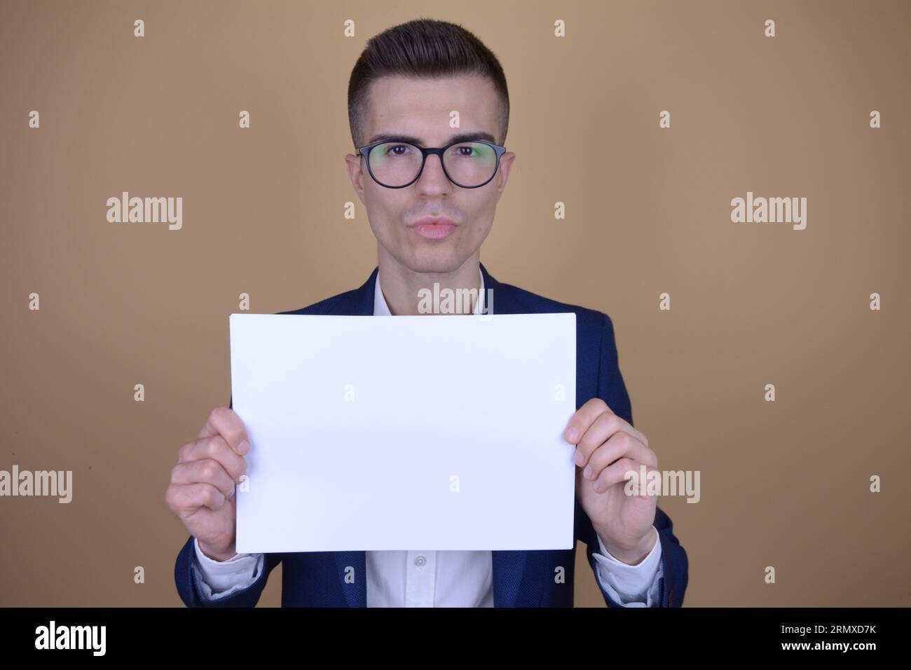 Serious Young Handsome Elegant Man tenant le livre blanc sur l'espace de copie sur fond isolé Banque D'Images