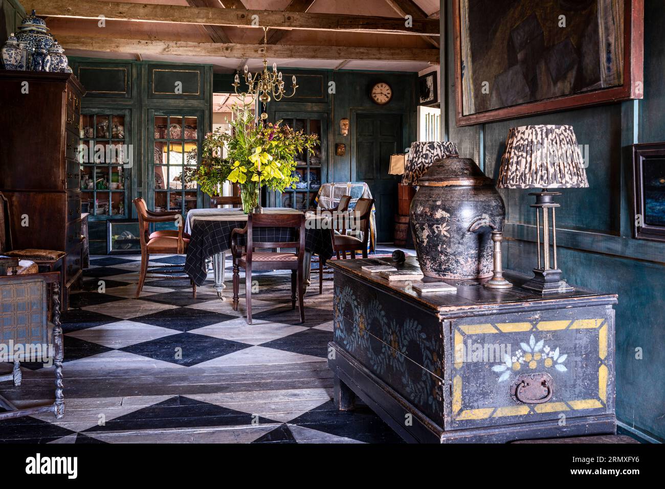 Salle à manger à aire ouverte avec des planches au pochoir avec un design en damier dans une conversion du 18e siècle en « loft fleuri » près de Penzance en Cornouailles, Royaume-Uni Banque D'Images