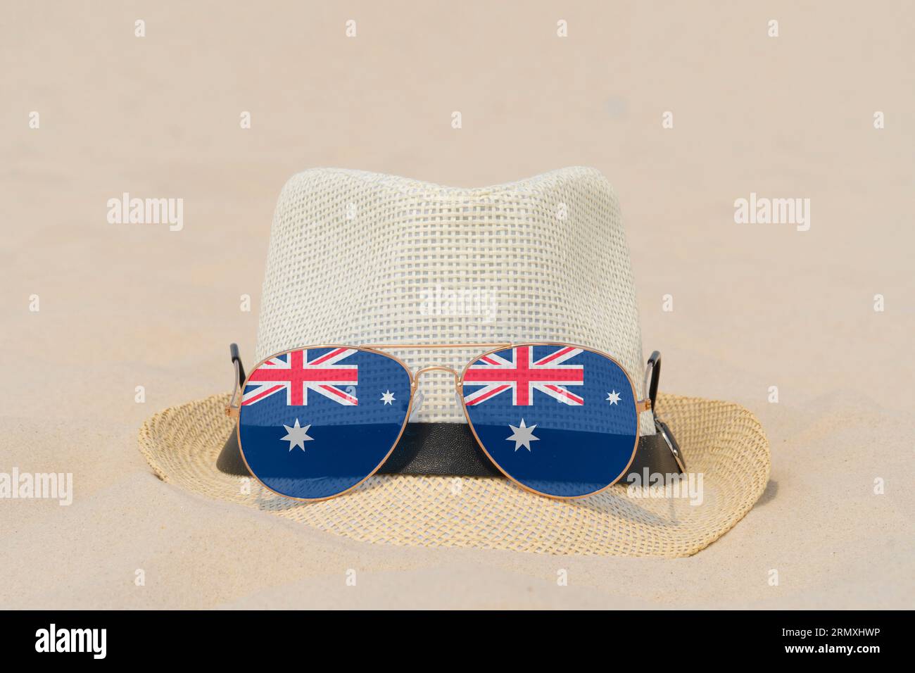 Lunettes de soleil avec des lunettes en forme de drapeau de l'Australie et un chapeau reposent sur le sable. Concept de vacances d'été et de voyages en Australie. Repos estival Banque D'Images