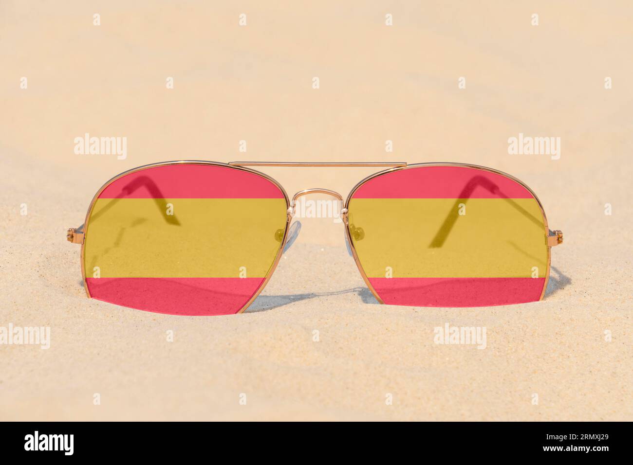 Lunettes de soleil avec des lunettes en forme de drapeau de l'Espagne reposent sur le sable. Concept de vacances d'été et de voyage en Espagne. Repos estival. Fêtes de fin d'année Banque D'Images