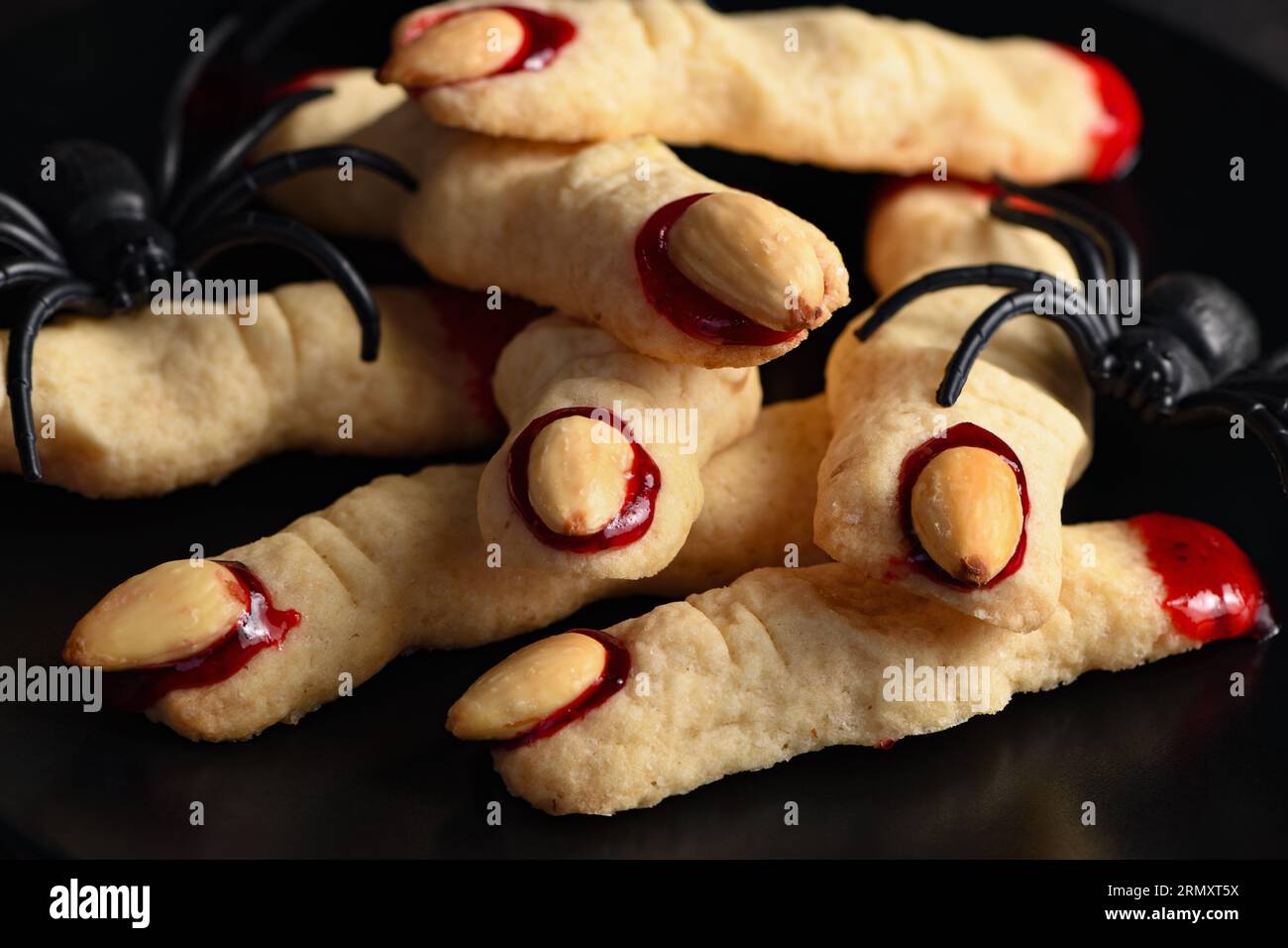 Doigts de sorcière effrayant et effrayant à base de biscuits au sucre avec confiture de framboises et amandes à Halloween. Friandises ou friandises. Classic cookie Witch Fingers prend le dessus Banque D'Images
