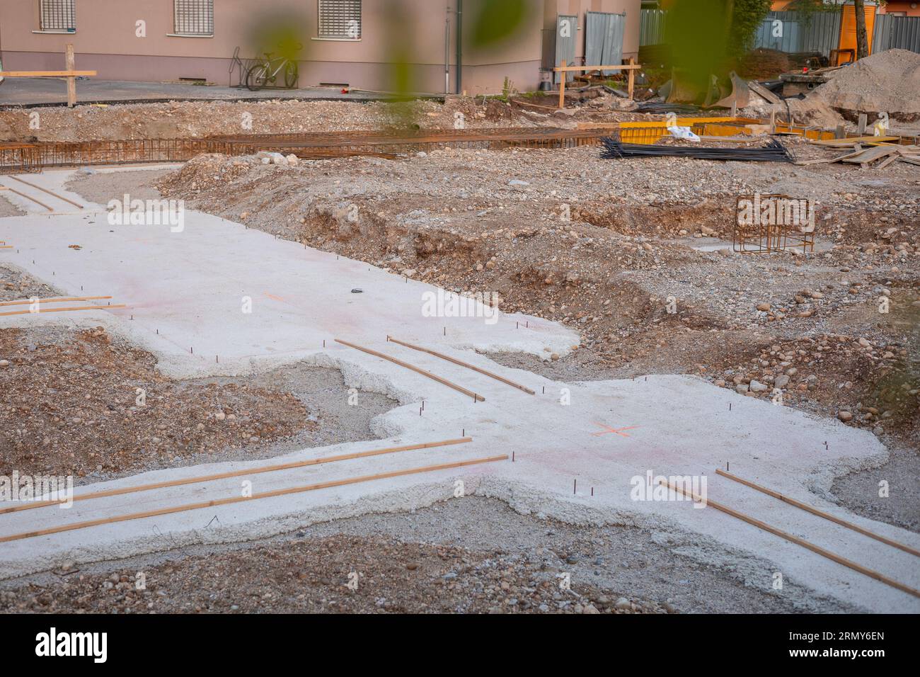 Fabrication d'une plaque de base pour un bâtiment, béton frais visible et acier d'armature sortant. Chantier de construction dans la ville, base en construction. Banque D'Images