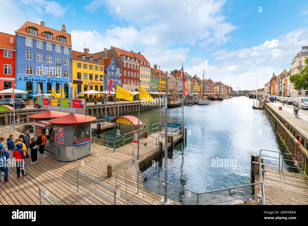 Bâtiments colorés avec des appartements, et des boutiques le long des terrasses de cafés et des voiliers amarrés au canal Nyhavn du 17e siècle. Banque D'Images