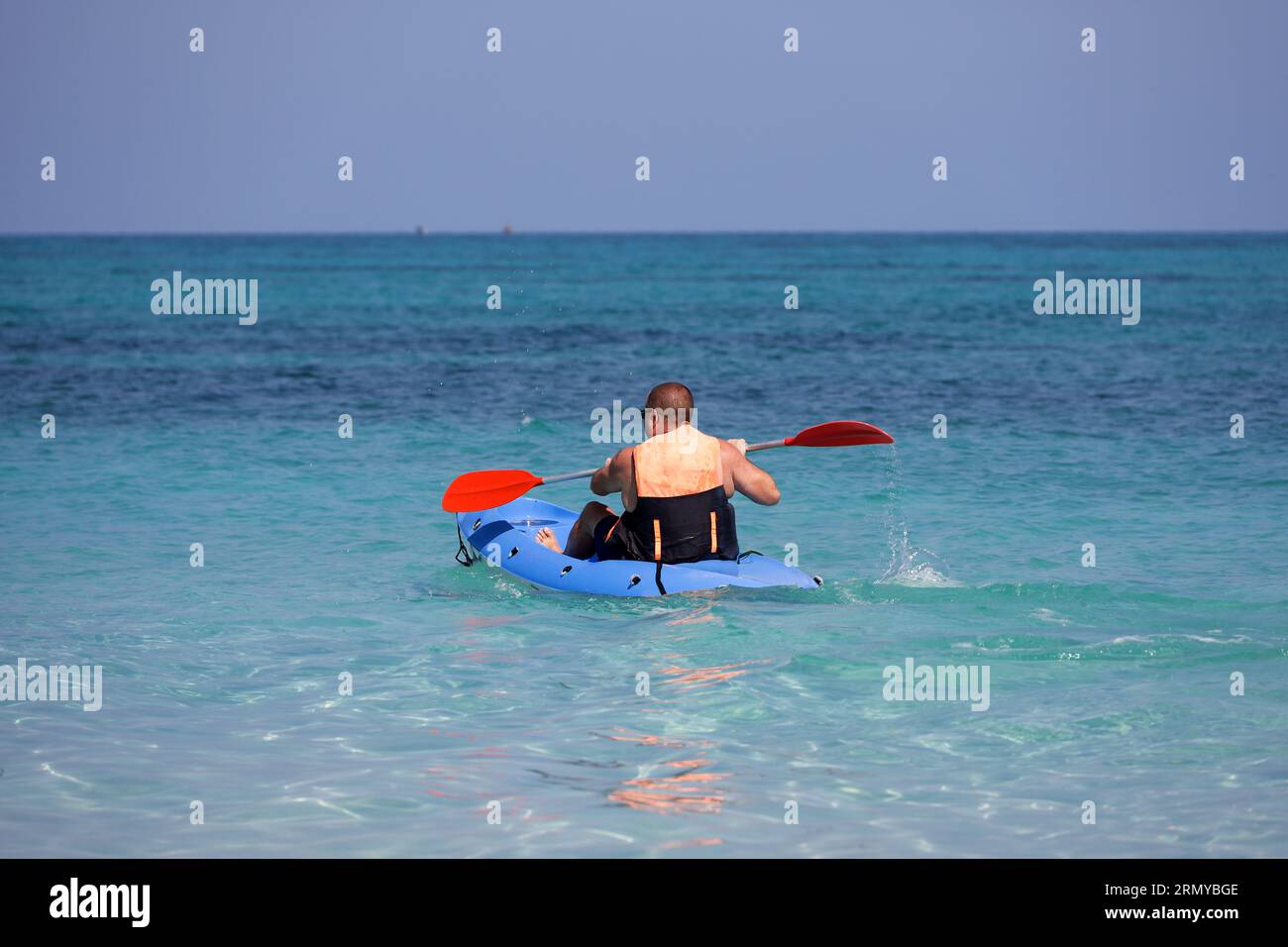 Kayak dans la mer, homme portant gilet de sauvetage assis avec paddle en canoë. Concept de voyage et de sports nautiques Banque D'Images