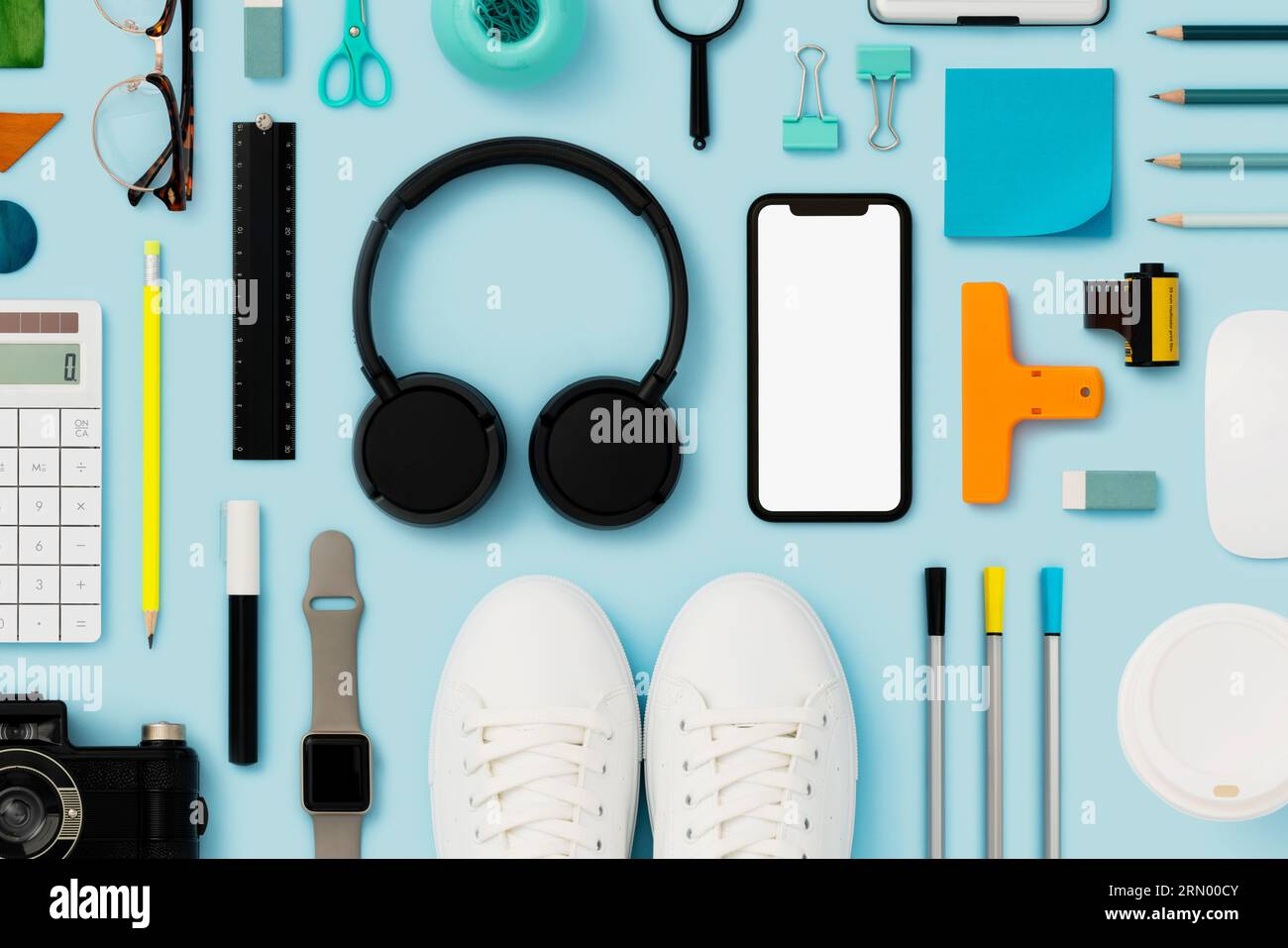Retour à l'école plat avec maquette de téléphone intelligent sur fond bleu. Accessoires personnels et objets du quotidien à plat Banque D'Images