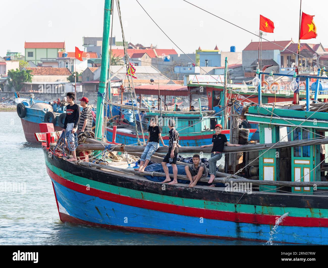Jeunes hommes à bord d'un bateau de pêche à Hai Thanh, un village de la province de Thanh Hoa au Vietnam. Banque D'Images