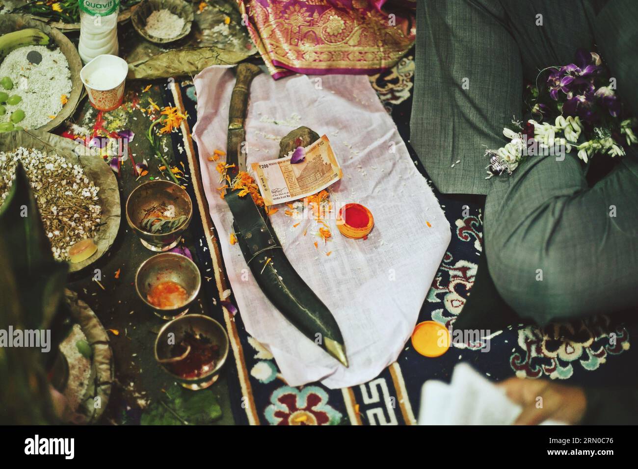 Cérémonie de mariage coutumière népalaise avec Khukuri, les chaussures du marié et les pieds de la mariée ornés de motifs complexes au henné et de ongles de pied ornés Banque D'Images