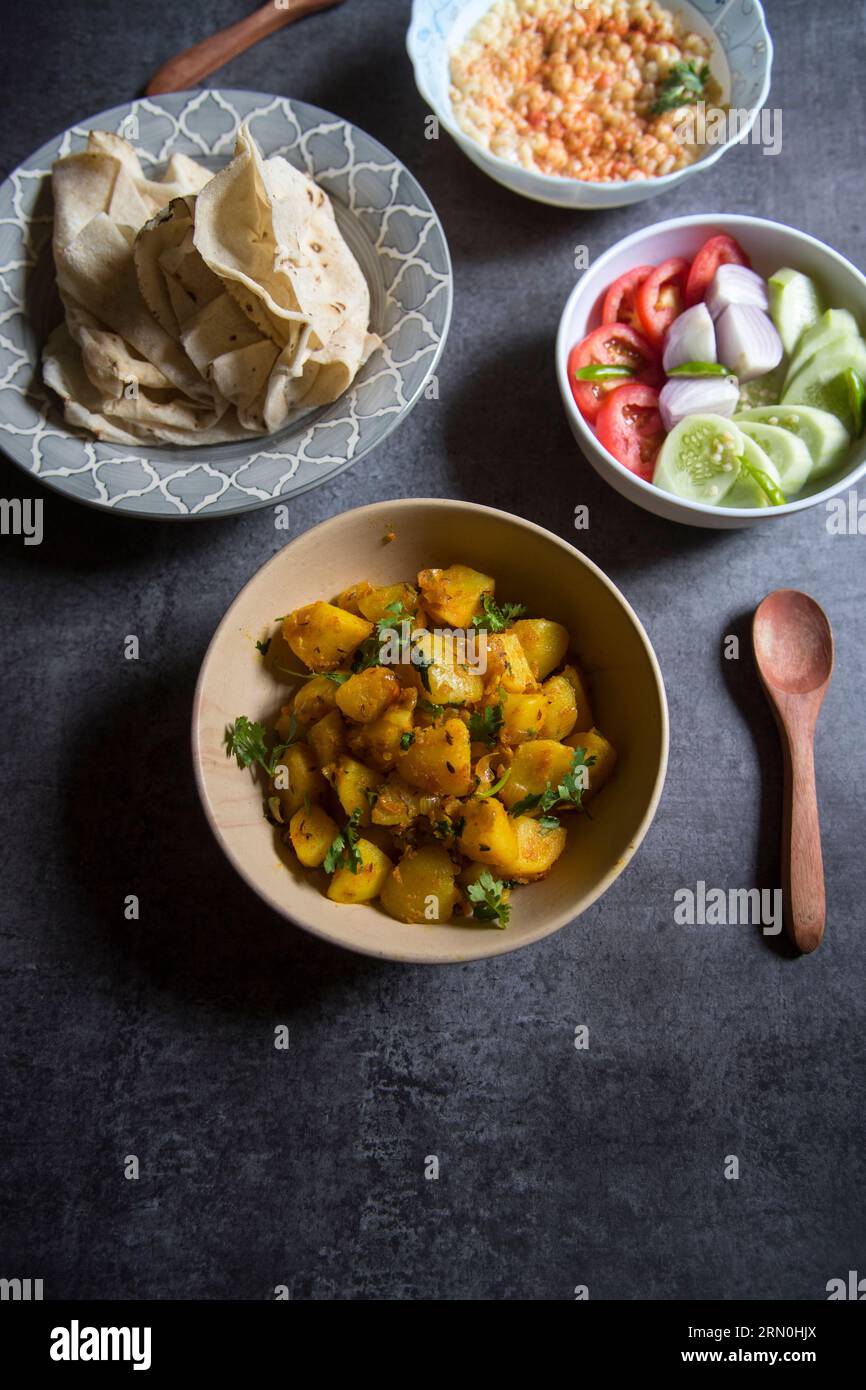 Aloo jeera ou pomme de terre masala servi avec du pain plat indien et de la salade. Banque D'Images