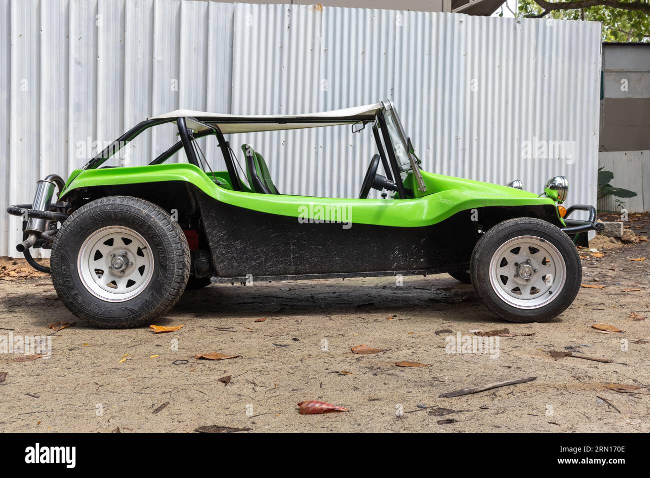 Mahé, Seychelles - 7 août 2023 : buggy de plage noir vert stationné par une journée ensoleillée, vue de côté Banque D'Images