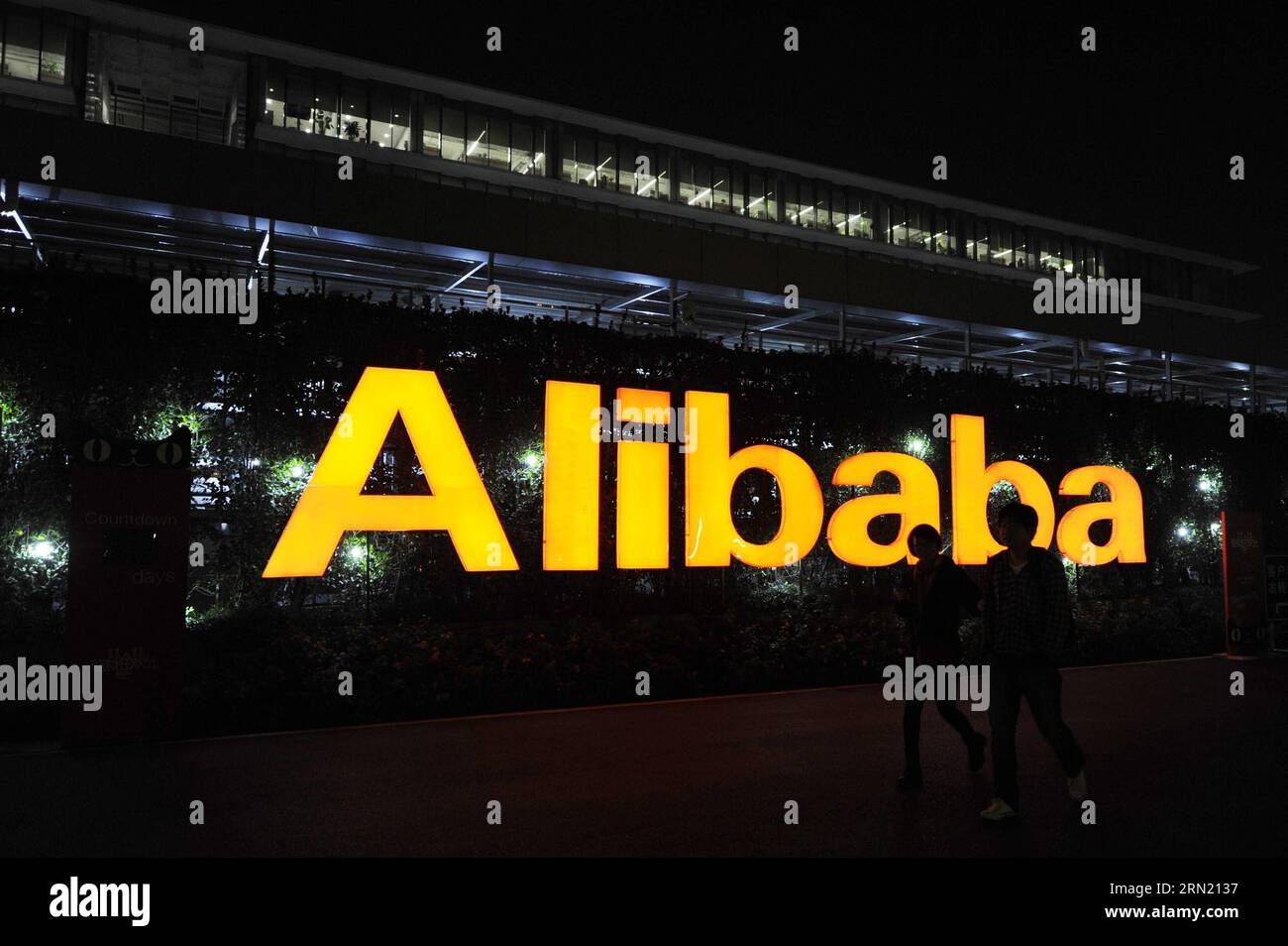 (150130) -- HANGZHOU, 30 janvier 2015 -- photo prise le 12 novembre 2014 montre deux membres du personnel marchant devant le logo d'Alibaba à la base Xixi d'Alibaba Group à Hangzhou, capitale de la province de Zhejiang de l'est de la Chine. Les actions d'Alibaba ont plongé jeudi alors que le rapport trimestriel du géant chinois du commerce électronique a montré une croissance des ventes plus faible que prévu. La société basée à Hangzhou, qui exploite les plus grands sites de shopping en ligne de Chine, Tmall et Taobao, a déclaré que les ventes sur ses plateformes ont atteint 787 milliards de yuans au quatrième trimestre. Alibaba a affiché un bond de 40 pour cent dans les ventes à environ 4,2 milliards de dollars américains, inférieur à Banque D'Images