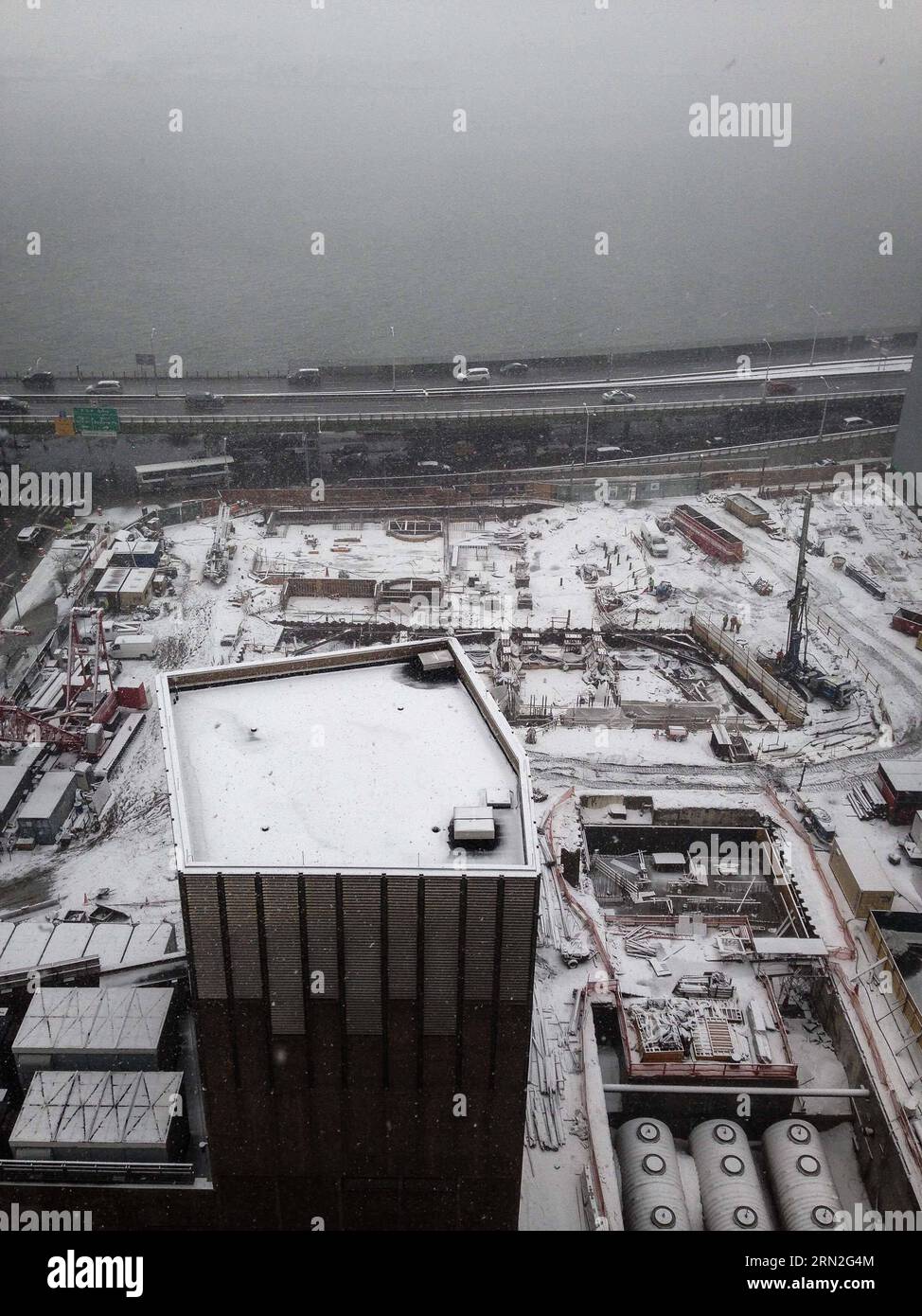 (150305) -- NEW YORK, 5 mars 2015 -- une photo prise avec un téléphone portable montre des véhicules passant devant un chantier de construction lors d'une forte chute de neige à Manhattan, New York, États-Unis, le 5 mars 2015. Une tempête hivernale puissante se déplaçant à travers l'est des États-Unis apporte de la neige abondante de parties de la vallée de l'Ohio au nord-est jeudi et met 94 millions de personnes sous avertissement de tempête hivernale ou avis de météo hivernale, US National Weather Service (NWS) a dit.) États-Unis-NEW YORK-MÉTÉO-NEIGE NiuxXiaolei PUBLICATIONxNOTxINxCHN New York Mars 5 2015 photo prise par téléphone portable montre DES VÉHICULES conduisant pas Banque D'Images