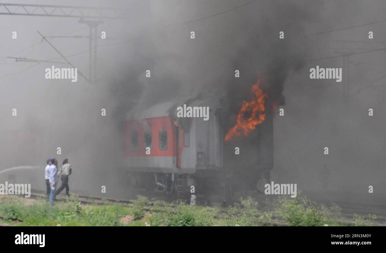 (150421) -- NEW DELHI, le 21 avril 2015 -- un pompier indien pulvérise de l'eau pour éteindre un incendie pris dans les voitures du train Sealdah Rajdhani à New Delhi, en Inde, le 21 avril 2015. Six bogies d'un train de passagers ont pris feu à la gare de New Delhi ici mardi, sans causer de victimes, a déclaré la police. INDE-NEW DELHI-TRAINS DE PASSAGERS-FIRE ParthaxSarkar PUBLICATIONxNOTxINxCHN New Delhi avril 21 2015 à Indian Fire Fighter pulvérise de l'eau pour étouffer un incendie pris dans les voitures du train Sealdah à New Delhi Inde avril 21 2015 six bogies d'un train de passagers ont pris feu À la New Del Banque D'Images