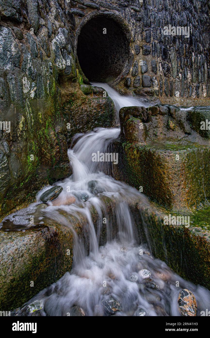 Tuyau de travail de l'eau du Sud-Ouest déversant l'eau sur la plage à Trevaunance Cove à St Agnes, Cornwall, Royaume-Uni , Banque D'Images