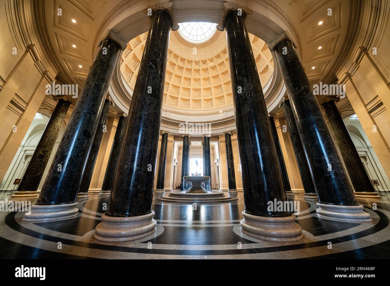 Rotonde de la National Gallery of Art Rotunda Washington DC // WASHINGTON, DC, États-Unis — la grande rotonde de la National Gallery of Art de Washington, DC, présente une architecture néoclassique avec son impressionnant dôme, sa lucarne et ses colonnes corinthiennes. Une fontaine centrale ajoute un élément dynamique à l’espace circulaire, qui sert d’entrée principale et de point focal du musée. La conception de la rotonde, avec une disposition symétrique et des proportions classiques, illustre la vision de l'architecte John Russell Pope. Banque D'Images