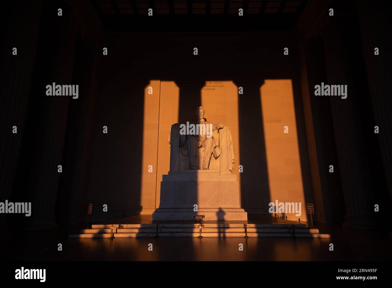 WASHINGTON DC, États-Unis — la statue du Lincoln Memorial, illuminée par la lumière dorée du lever du soleil pendant le solstice de printemps, projette une lueur chaude sur le monument historique. Cet événement solaire spécifique accentue les caractéristiques de l'hommage emblématique au 16e président américain, soulignant le rôle d'Abraham Lincoln dans l'histoire de la nation. Banque D'Images