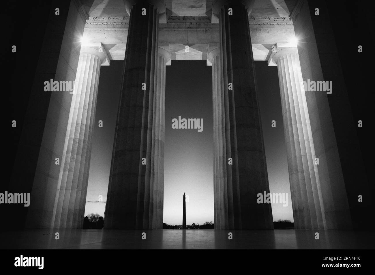 Colonnes du Lincoln Memorial au lever du soleil, Washington, D.C. photographie en noir et blanc montrant une vue de l'intérieur du mémorial, regardant vers le Washington Monument. Banque D'Images