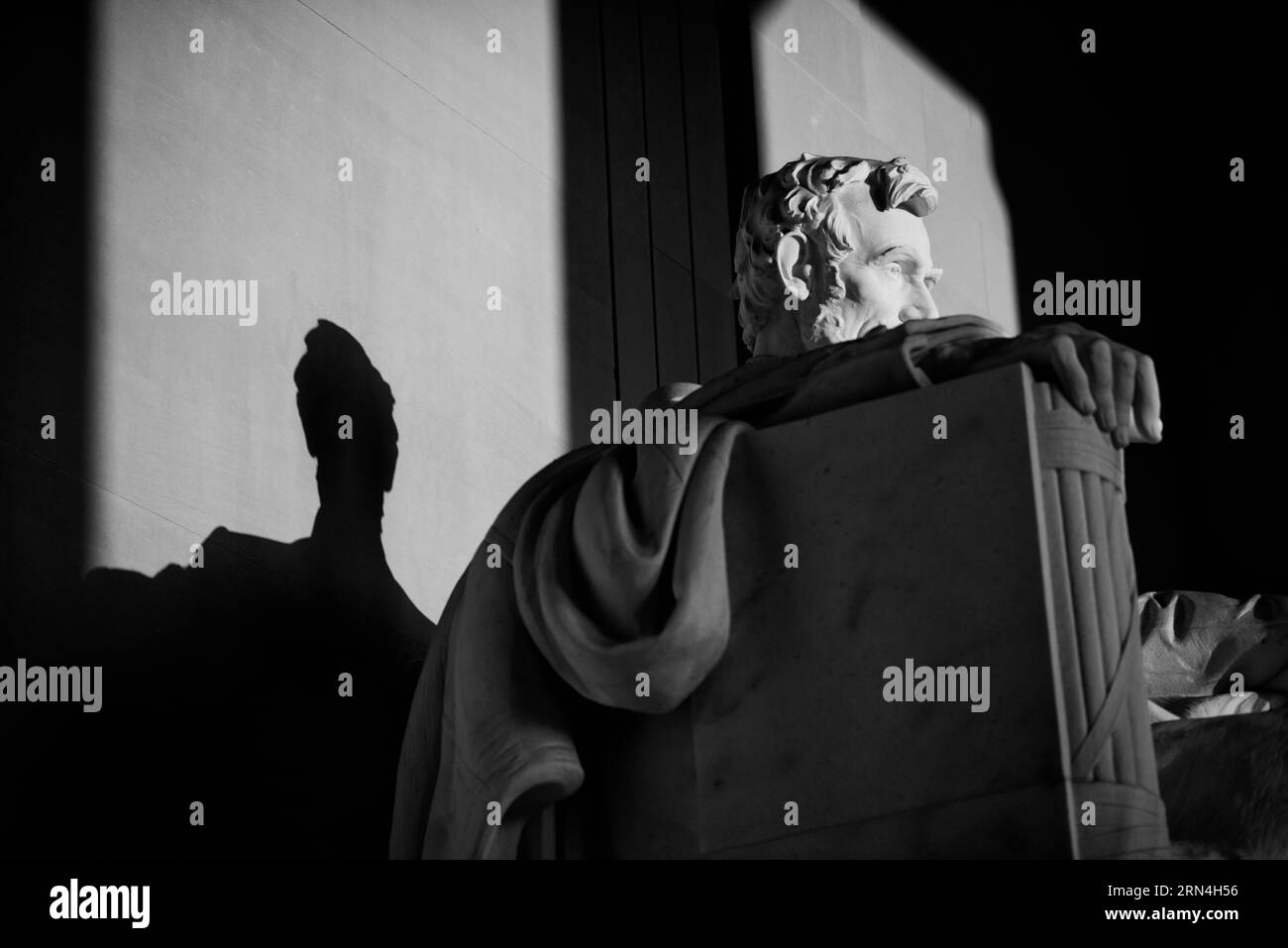 Statue d'Abraham Lincoln, Lincoln Memorial, Washington DC — Photo noir et blanc | Statue d'Abraham Lincoln, Lincoln Memorial, Washington, D.C., sous une lumière dramatique. Photographie noir et blanc montrant un gros plan de la tête et des épaules de la statue, avec son ombre projetée sur le mur. Banque D'Images