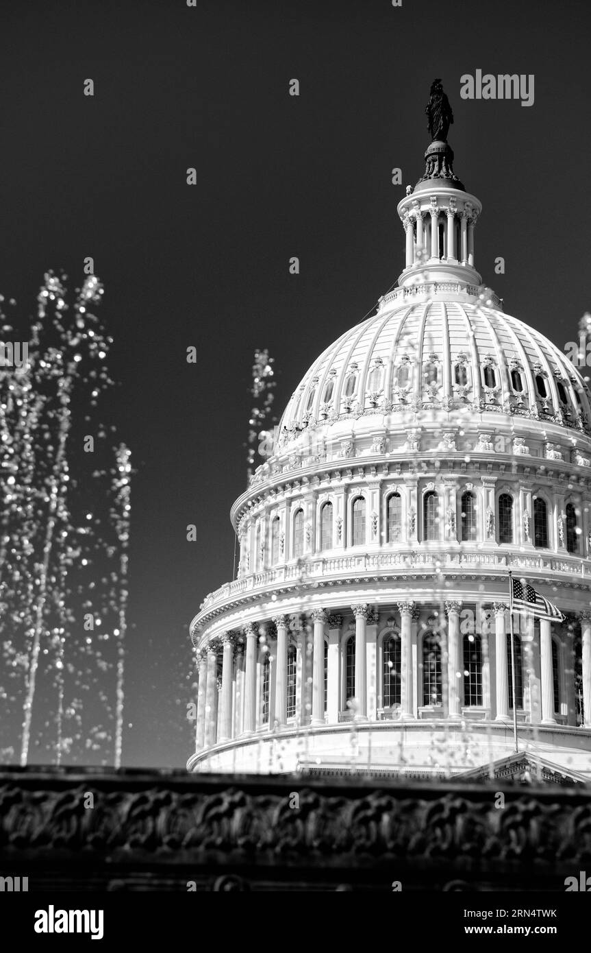 US Capitol Dome and Fountains, Washington, DC photographie en noir et blanc montrant le dôme vu à travers les fontaines d'eau, avec le drapeau américain visible. Banque D'Images
