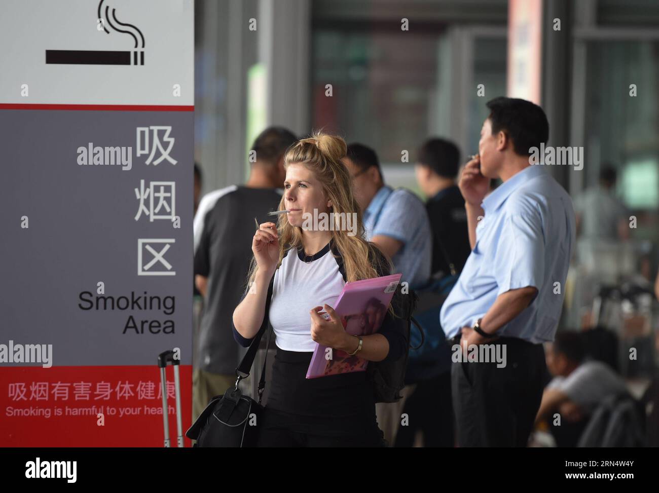 (150601) -- PÉKIN, le 1 juin 2015 -- les gens fument dans une zone fumeur à l'extérieur du terminal 3 de l'aéroport international Capital à Pékin, capitale de la Chine, le 1 juin 2015. Une nouvelle interdiction de fumer est entrée en vigueur à Pékin le 1 juin. La nouvelle interdiction, la plus sévère du pays à ce jour, interdit de fumer dans tous les lieux publics intérieurs de la ville, les lieux de travail et les transports en commun. Suite à l interdiction, l aéroport de la capitale a fermé lundi trois fumoirs dans ses trois terminaux et ouvert 11 espaces fumeurs à l extérieur.) (wf) CHINE-BEIJING-INTERDICTION DE FUMER (CN) LuoxXiaoguang PUBLICATIONxNOTxINxCHN 150601 Beijing juin 1 2 Banque D'Images