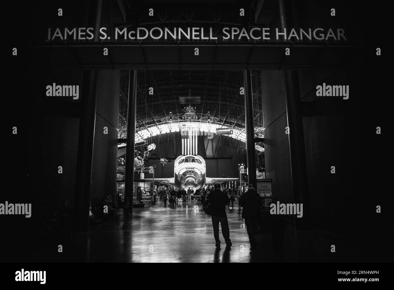 Navette spatiale découverte au musée de l'air et de l'espace Smithsonian, comté de Fairfax. Photographie en noir et blanc montrant la navette encadrée par l'entrée du hangar spatial James S. McDonnell. Banque D'Images