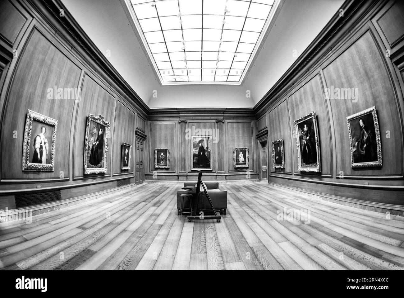 Peintures dans la galerie, Washington, DC photographie en noir et blanc montre une perspective fisheye de portraits encadrés tapissant les murs lambrissés et le plancher de bois franc. Banque D'Images