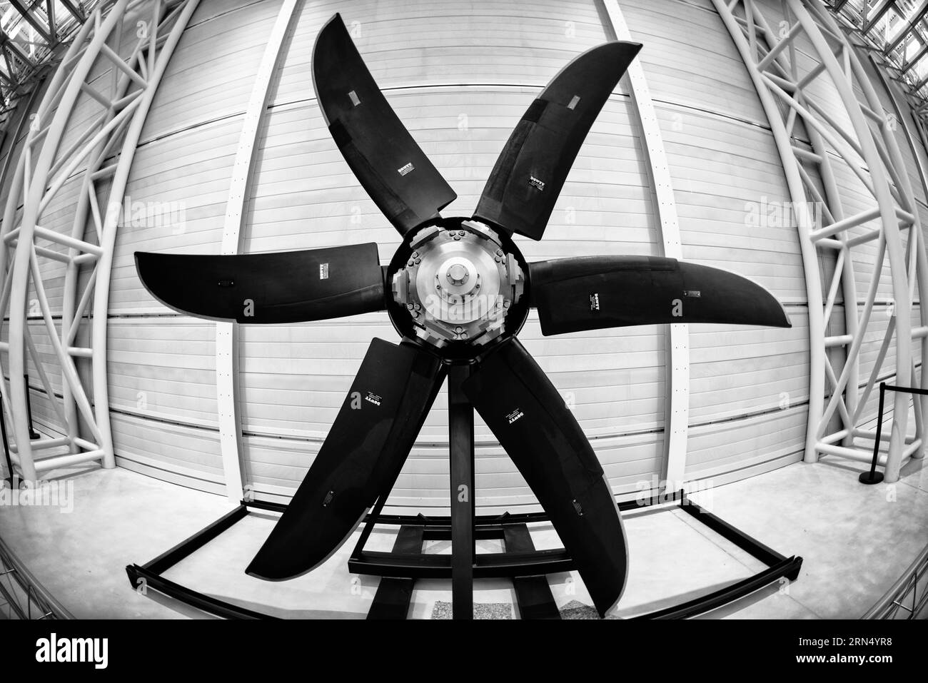 Hélice d'avion, Udvar-Hazy Center, comté de Fairfax. La photographie en noir et blanc montre une hélice à cinq pales avec un effet fisheye, posée contre un mur incurvé et une structure de plafond. Banque D'Images